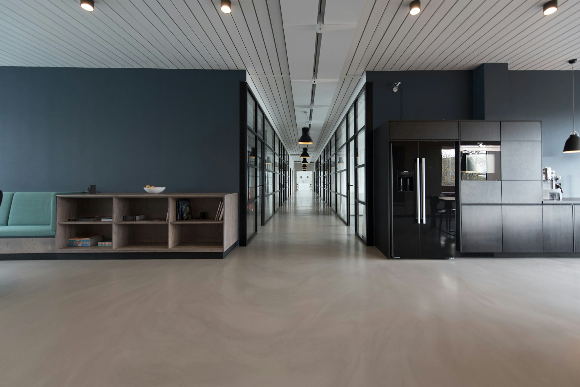 Generate an image of: An empty modern office interior with dark metal beams and glowing yellow strip lighting, depth of field, sleek and industrial